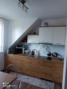 a kitchen with white cabinets and a sink at Apartament Gajówka z ogrodem na wyłączność, Energylandia 35min in Rzyki