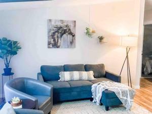 a living room with a blue couch and a painting of a horse at Renovated Bungalow Getaway in Philomath