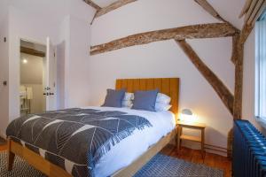 een slaapkamer met een groot bed met een houten hoofdeinde bij Coventry Historic Houses in Coventry