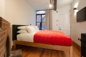 ein Schlafzimmer mit einem Bett mit einer roten Decke in der Unterkunft Coventry Historic Houses in Coventry