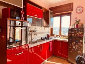 een keuken met rode kasten en een groot raam bij Napoli Centro in Napels