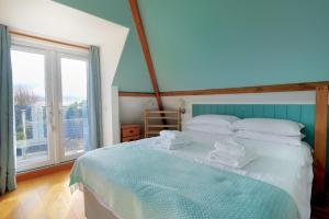 a bedroom with a bed and a large window at Hove To in Lyme Regis