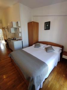 ein Schlafzimmer mit einem großen Bett und einem Waschbecken in der Unterkunft Pluton in Primošten