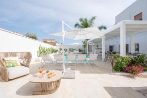 a patio with a table and chairs and an umbrella at Il Moro Camere&Relax in San Vito lo Capo