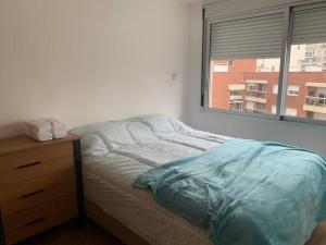 1 cama no hecha en un dormitorio con ventana en Puerto Aventura, en Montevideo