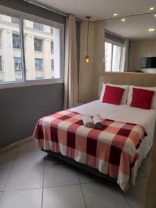 a bedroom with a bed with a checkered blanket at Apartamento no centro de São Paulo in Sao Paulo