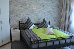 1 dormitorio con 1 cama con sábanas y almohadas verdes en Ferienwohnung am Keltenweg, en Steineberg