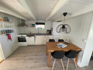 a kitchen with a wooden table and chairs at Lofoten_Beach_Eggum_Cabin in Eggum