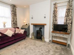 uma sala de estar com um sofá e uma televisão em Myrtle Cottage em Preston