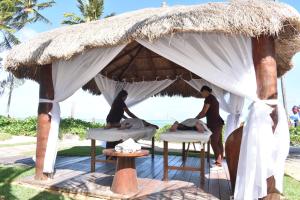 um grupo de pessoas sentadas em camas numa tenda em Grand Oca Maragogi All Inclusive Resort em Maragogi