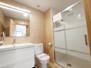 y baño con aseo, lavabo y ducha. en Apartamento PATXIKE con plaza de garaje, en Bermeo