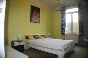 een slaapkamer met een bed met gele muren en een raam bij Echappée mosane in Waulsort