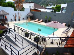 a large swimming pool with chairs and an umbrella at Lion D`Or in Villa Carlos Paz