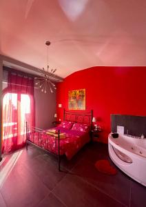 ボルディゲーラにあるVilla Gaia - Luxury Villa, pool & wellness roomsの赤いベッドルーム(ベッド1台、バスタブ付)