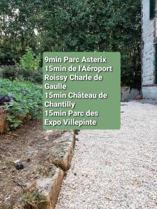 znak w ogrodzie z napisami na nim w obiekcie Résidence du Houx - 4 (Astérix, Aéroport CDG, Chantilly, Parc expos...) w mieście Survilliers