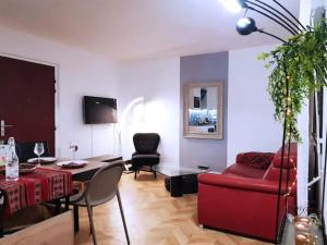een woonkamer met een rode bank en een tafel bij Pretty and neat bedroom in my cosy appartment. in Puteaux