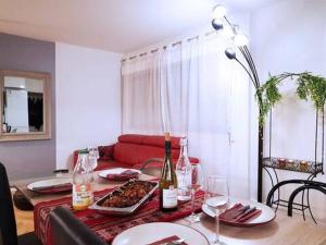 een woonkamer met een tafel met een rode bank bij Pretty and neat bedroom in my cosy appartment. in Puteaux