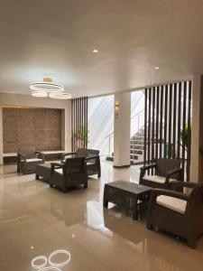 un hall avec des chaises et des tables dans un bâtiment dans l'établissement Oasis Hotel, à San Andrés