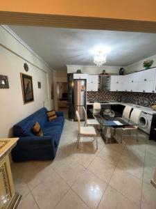 ein Wohnzimmer mit einem blauen Sofa und einer Küche in der Unterkunft Lititsia apartment in Thessaloniki