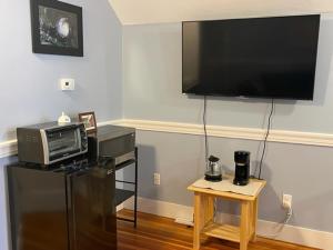 un soggiorno con TV, forno a microonde e tavolo di Comfortable loft with private bathroom a Boston