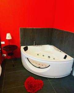 a bath tub in a room with a red wall at Villa Gaia - Luxury Villa, pool & wellness rooms in Bordighera