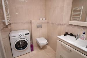 een badkamer met een wasmachine en een wastafel bij Elegance 1BD apartment with living room in Chişinău