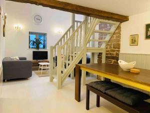 a living room with a wooden table and a staircase at The Owl House Cottage in Welsh Newton Common