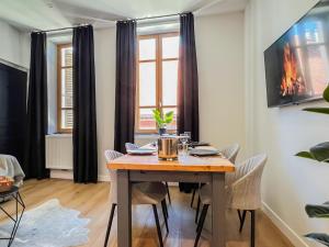 a dining room with a wooden table and chairs at Balneo village vieille ville in Annecy