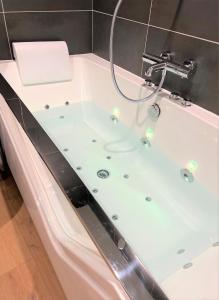 a bathroom with a bath tub with lights in it at Balneo village vieille ville in Annecy