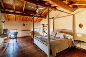 ein Schlafzimmer mit Himmelbett und Schreibtisch in der Unterkunft Dimora Valverde B&B in Marano di Valpolicella
