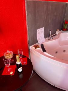 博爾迪蓋拉的住宿－Villa Gaia - Luxury Villa, pool & wellness rooms，浴室设有白色浴缸和带酒杯的桌子
