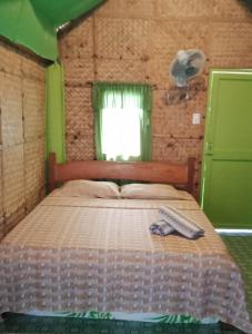 ein Schlafzimmer mit einem Bett und einem Handtuch darauf in der Unterkunft Lorenza's Cottage 1 in Buruanga