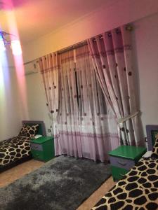 1 dormitorio con 2 camas individuales y cortinas rosas en Villa Ceni 2 en Elbasan