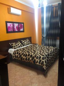 1 dormitorio con 1 cama con manta blanca y negra en Villa Ceni 2 en Elbasan