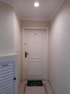 un pasillo con una puerta blanca y una alfombra en Apto 4 Quartos em Itapema, en Itapema