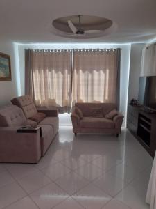 sala de estar con 2 sofás y TV de pantalla plana en Apto 4 Quartos em Itapema, en Itapema