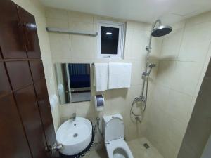 a bathroom with a toilet and a sink and a window at Tour Inn in Male City