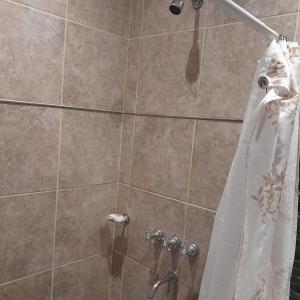 a shower with a white shower curtain in a bathroom at Kaedo in Corrientes