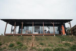a house with a black roof on top of a hill at CASA DE VIDRO EM MEIO A NATUREZA - Conteiner Lua in Piçarras