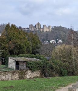 un château au sommet d'une colline avec un champ verdoyant dans l'établissement La Petite Maison, à Saint-Rémy-lès-Chevreuse