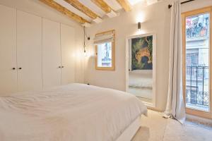 a white bedroom with a bed and a window at La Palma Barceloneta Penthouse Apartment with Roof Top Terrace in Barcelona