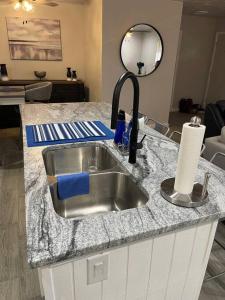 a kitchen counter with a sink and a mirror at Cozy, Fam Friendly Home Min from Stkyards in Fort Worth