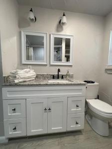 a white bathroom with a sink and a toilet at Cozy, Fam Friendly Home Min from Stkyards in Fort Worth