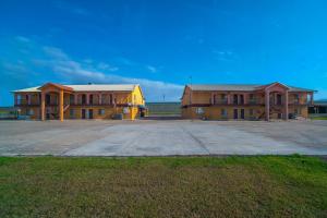 two buildings in a parking lot in a field at Texas Inn San Benito near Harlingen in San Benito