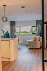 een woonkamer met een bank en een tafel bij Wellness Bed & Breakfast by Leef in Maasland