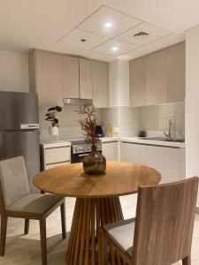 uma cozinha com uma mesa e cadeiras de madeira e uma cozinha com em Out of Mood ! luxury stay!! Abu Dhabi Yas Island em Abu Dhabi