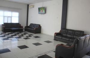 a waiting room with black leather chairs and a checkered floor at Andalusia Hotel in Nouakchott