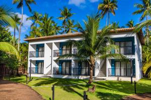 um edifício com palmeiras em frente em Vivant Eco Beach OFICIAL em Barra Grande