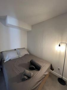 Cette petite chambre comprend un lit avec deux oreillers et une lampe. dans l'établissement "Lou Mes" Baux-de-provence Balcon, aux Baux-de-Provence