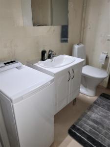 La salle de bains blanche est pourvue d'un lavabo et de toilettes. dans l'établissement Best possible location, 1 bedroom apartment, à Närpiö